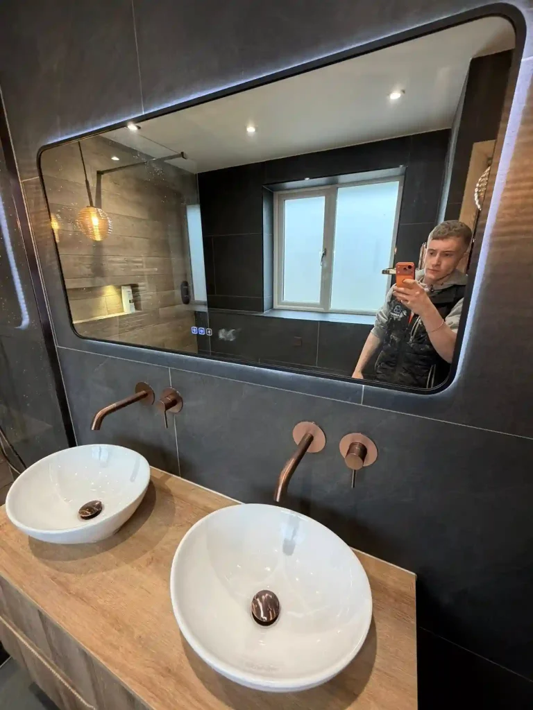 Luke Broxton from LB plumbing in Bacup taking photos of newly fitted bathroom.